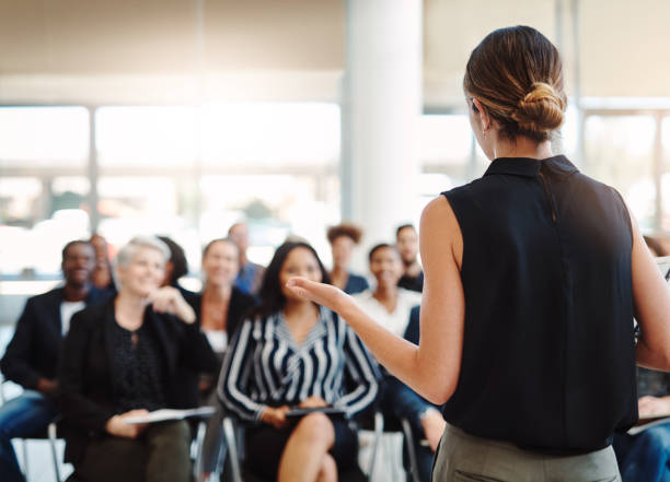 Delivering an informative presentation like a pro Shot of a young businesswoman delivering a speech during a conference convention center stock pictures, royalty-free photos & images