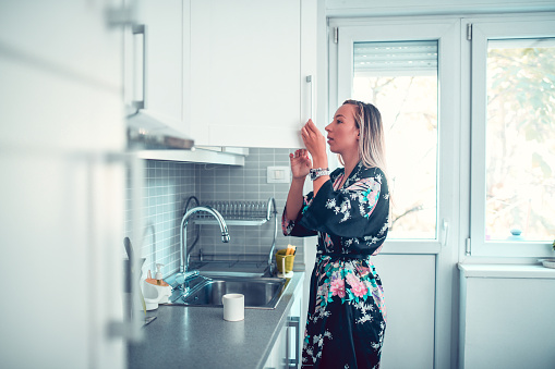 Housewife Searching For Coffee In Cupboard