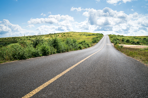 Empty asphalt road and green field.