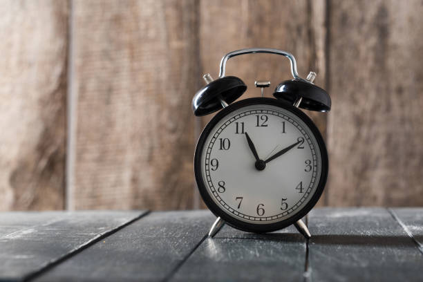 istock Alarm clock on an old wooden table 1141466297