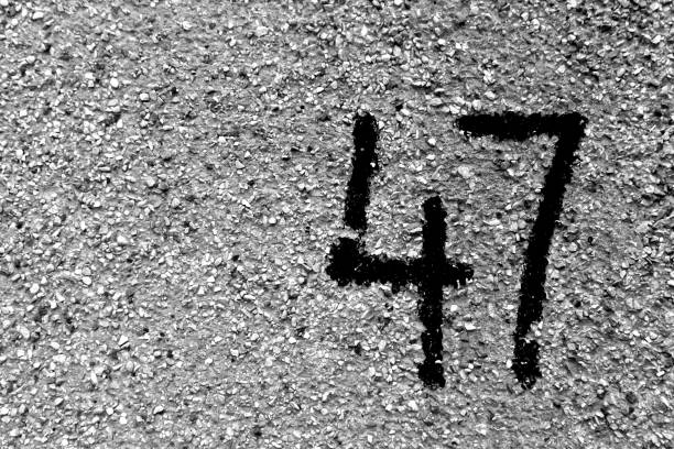 istock Number 47 on cement wall in stencil in black and white. 1141468216