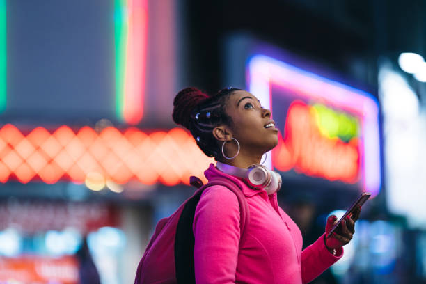 mujer usando teléfono inteligente en la noche - travel red vacations outdoors fotografías e imágenes de stock