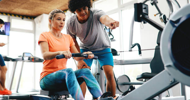 istock Young beautiful woman doing exercises with personal trainer 1141473982