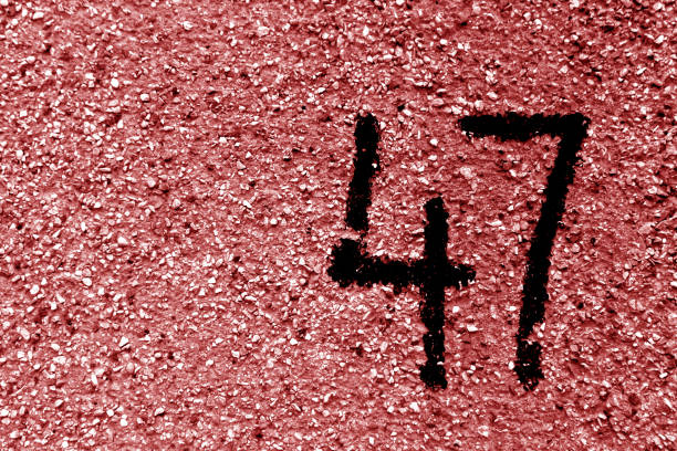 istock Number 47 on cement wall in stencil in red tone. 1141474174