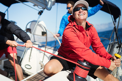 Attractive strong woman sailing with her sail boat