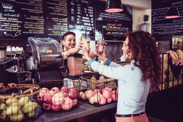 istock Cute Female Picking Up Smoothies From Bartender 1141474467