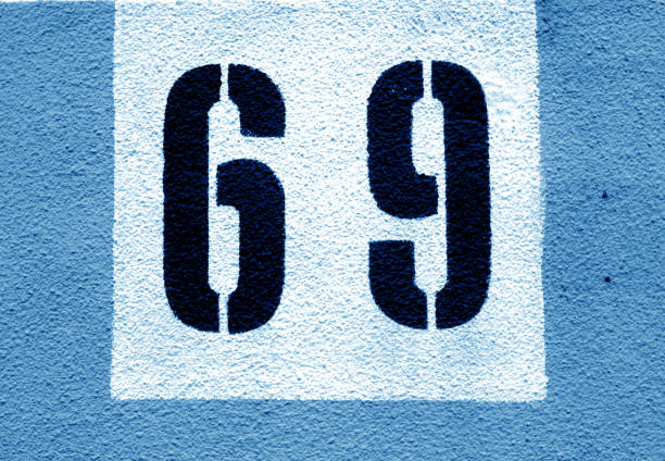 istock Number 69 on cement wall in stencil in navy blue tone. 1141475342