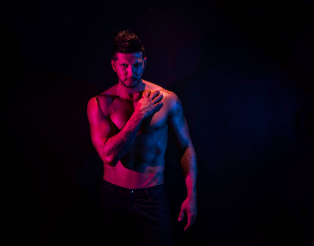 istock Handsome man in front of black background with red and blue lighting 1141475986