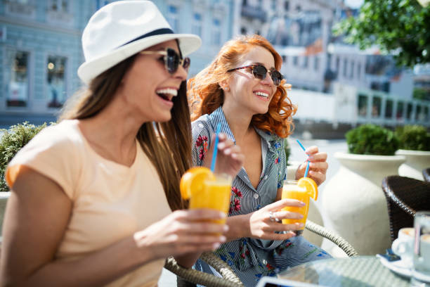 Beautiful girls having fun smiling together in a cafe outdoor Beautiful girls women having fun smiling together in a cafe outdoor terraced field stock pictures, royalty-free photos & images