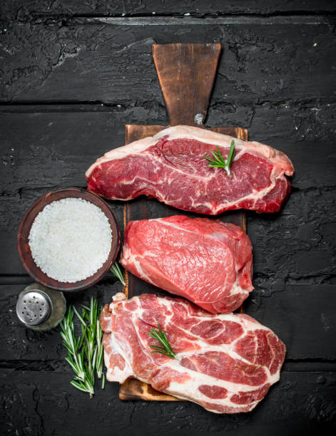 istock Raw meat. Pork and beef steaks with salt and spices. 1141481058