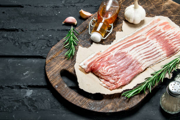 istock Raw bacon with rosemary and spices. 1141481284