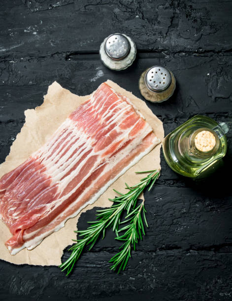 istock Raw bacon with rosemary and spices. 1141481292
