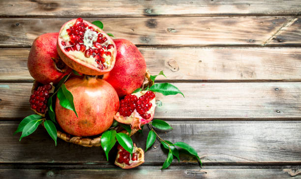 istock Fresh pomegranates with leaves in a basket. 1141481974