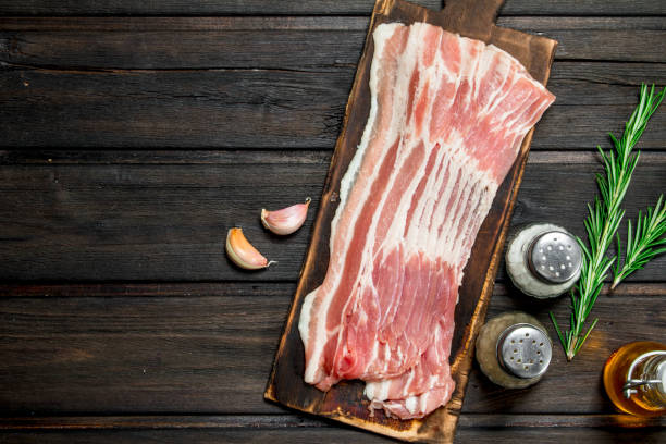 istock Raw bacon with rosemary and spices. 1141484758