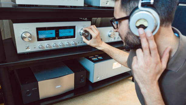 Man turning up the volume on home Hi-Fi stereo for louder music