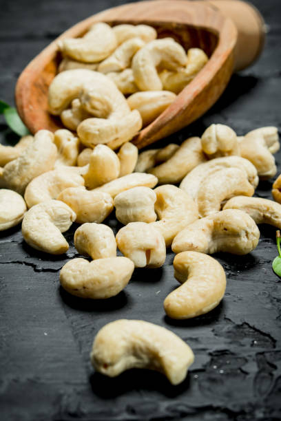 istock Cashew nuts in a wooden scoop with leaves. 1141485251