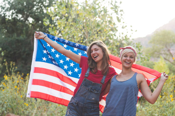 istock Two friends drape themselves in an American flag outside 1141488599