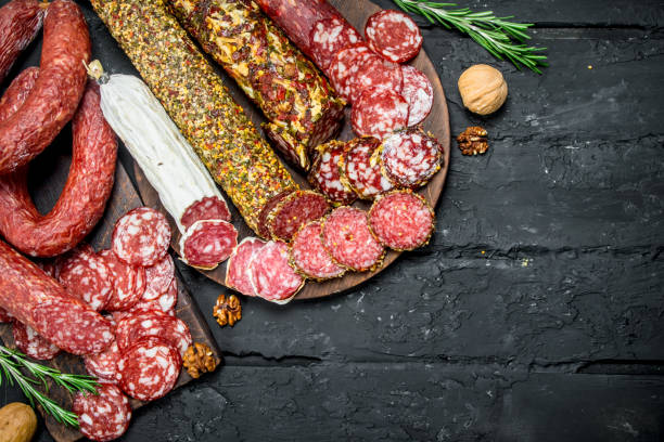 istock Different types of salami on wooden Board. 1141489176