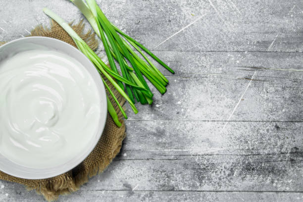 istock Sour cream with green onions in bowl . 1141490930