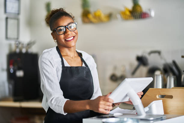 istock friendly shop assistant ready to take customer orders at register in restaurant 1141493414
