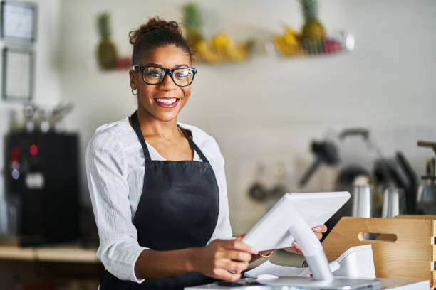 istock friendly shop assistant ready to take customer orders at register in restaurant 1141493726