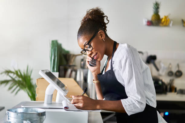 istock friendly waitress taking order on phone at restaurant and writing on notepad 1141493920