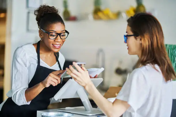 Photo of customer using online coupon from smartphone app at restaurant