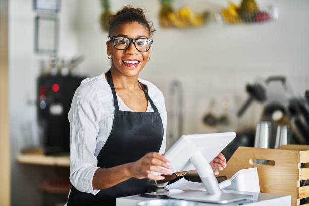 istock friendly shop assistant ready to take customer orders at register in restaurant 1141494952