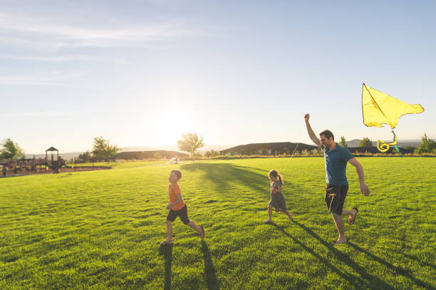 istock Dad flying kites with his kids at the park 1141495460
