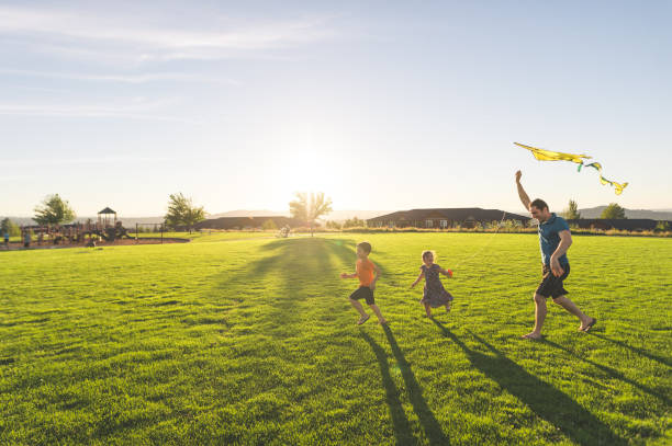 istock Dad flying kites with his kids at the park 1141495467