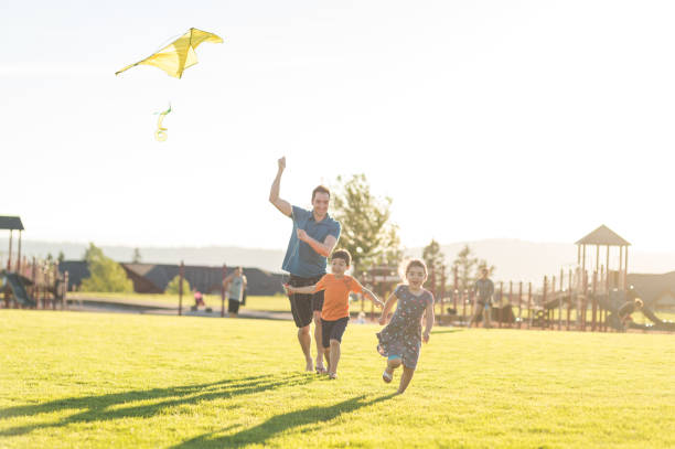 istock Dad flying kites with his kids at the park 1141495911