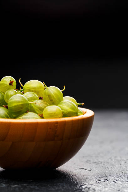 istock Gooseberry berries in wooden cup . 1141495976