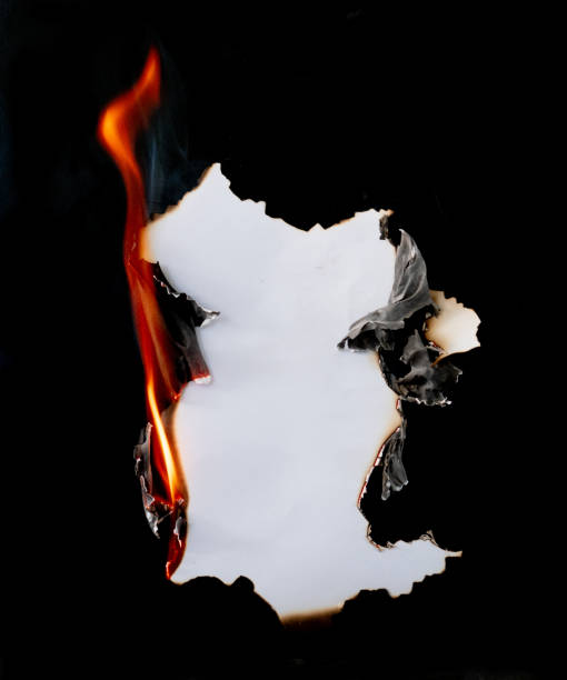 istock burning piece of  paper on black background 1141499184