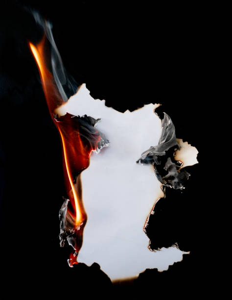 istock burning piece of  paper on black background 1141499285