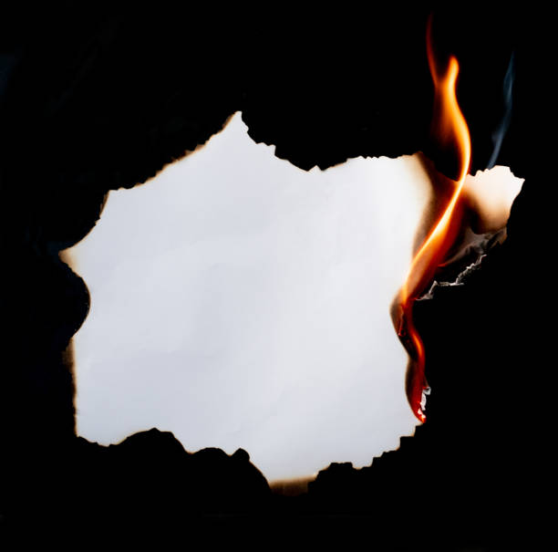 istock burning piece of  paper on black background 1141499348