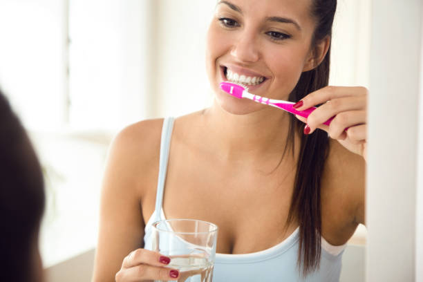 istock Pretty young woman brushing her teeth in the bathroom. 1141501892