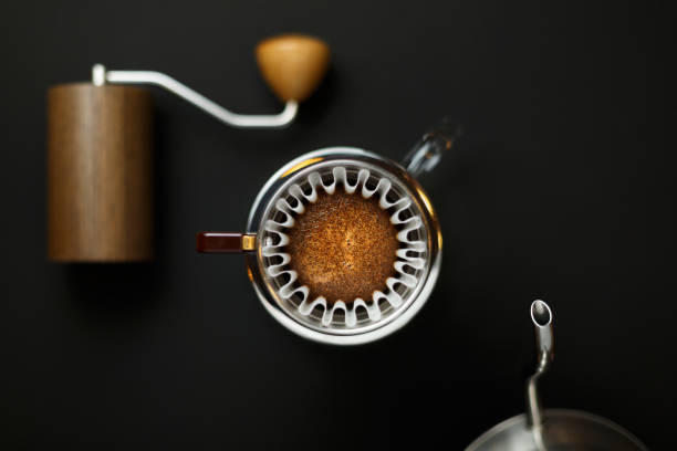 istock alternative method of brewing coffee. Bloom process. Hot water is poured into the ground coffee. Left coffee grinder right teapot blurred 1141501945