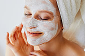 Beautiful young woman with facial mask on her face