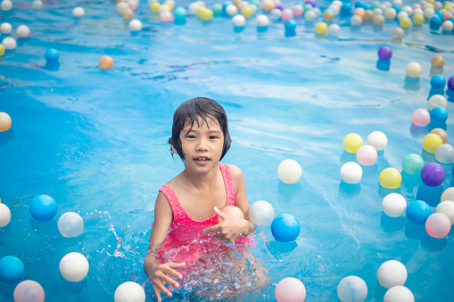 Kids playing and swimming in swimming pool on summer holidays time