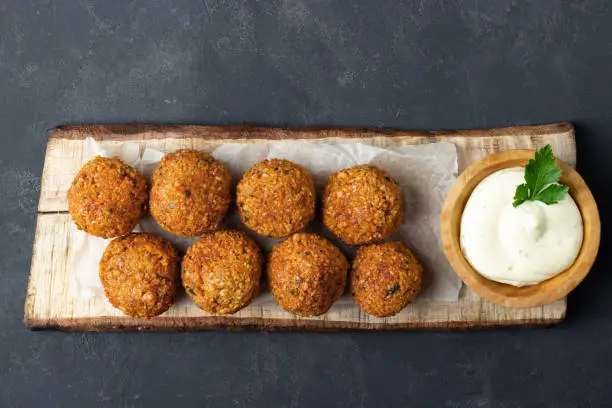 Overhead image of Arabic snack falafel in the form of chickpea balls with spices. Dark slate background.