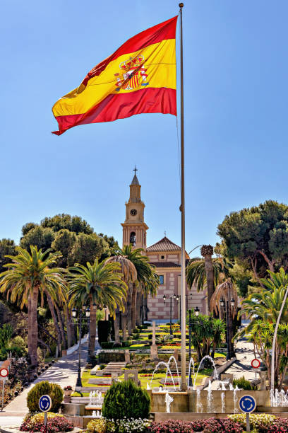istock Spanish flag flying on a pole with urban background. 1141506845