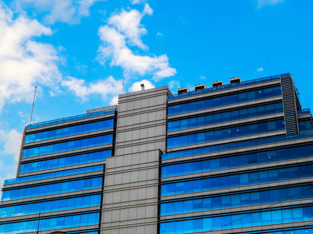 istock Glass building with blue windows and blue sky above 1141508312