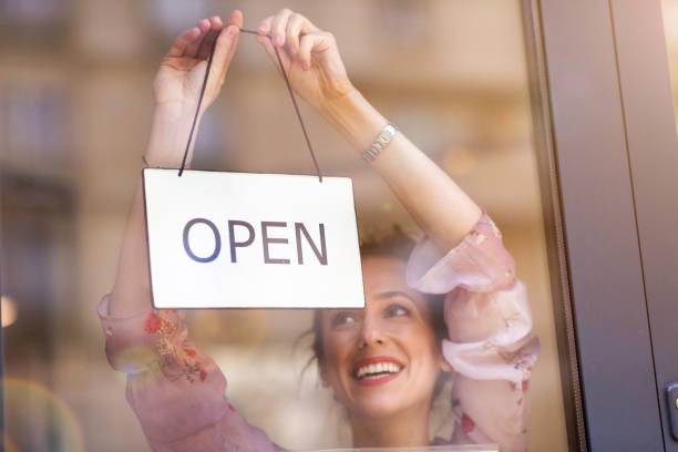 istock Woman holding open sign in cafe 1141511795
