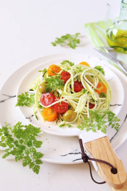 istock Raw food diet: uncooked spaghetti zucchini, cherry tomatoes, olives salad 1141514539
