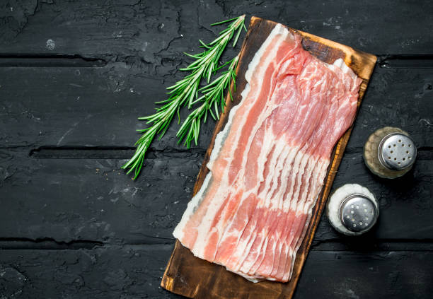 roher speck mit rosmarinzweigen. - raw bacon stock-fotos und bilder