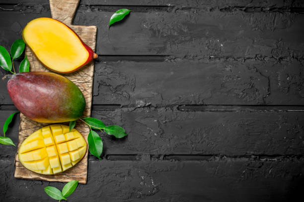 istock Whole and pieces of mango on the cutting Board. 1141516499