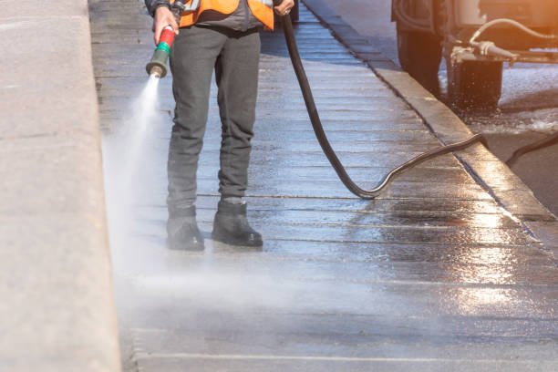 Worker cleaning driveway with gasoline high pressure washer splashing the dirt, granite embankment. High pressure cleaning. Worker cleaning driveway with gasoline high pressure washer splashing the dirt, granite embankment. High pressure cleaning carpet sweeper stock pictures, royalty-free photos & images