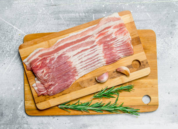 istock Raw bacon with rosemary and garlic. 1141516669