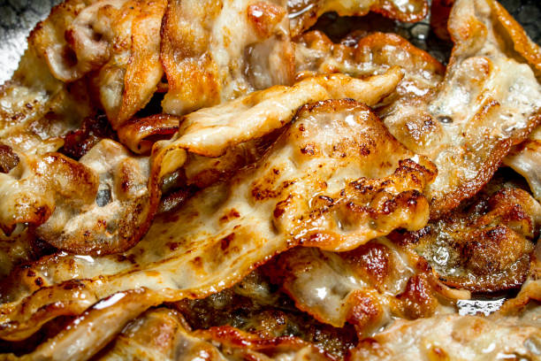 istock Fried bacon in a frying pan. 1141517356
