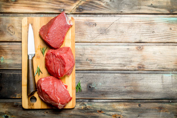istock Raw meat. Pieces of beef with a knife . 1141519128